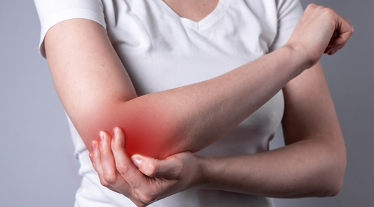 Person holding sore arm experiencing joint or muscle pain